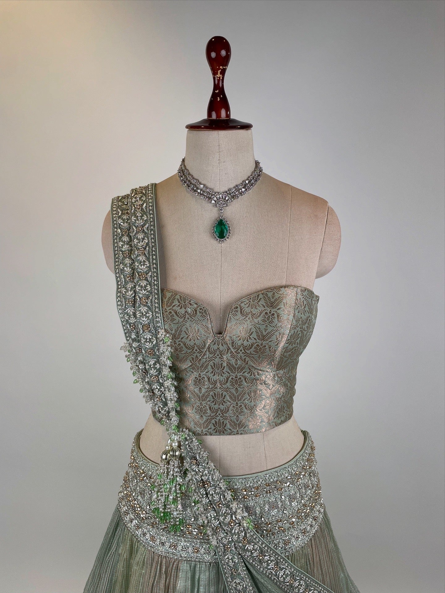MINT GREEN KOTA TISSUE LEHENGA EMBELLISHED WITH CRYSTALS AND ZARDOZI PAIRED WITH BANARASI CORSET BLOUSE