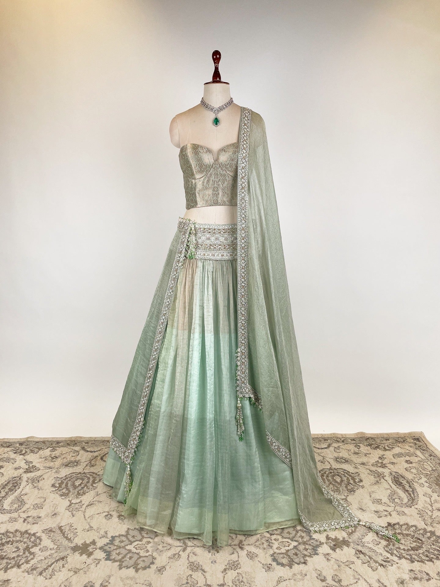 MINT GREEN KOTA TISSUE LEHENGA EMBELLISHED WITH CRYSTALS AND ZARDOZI PAIRED WITH BANARASI CORSET BLOUSE